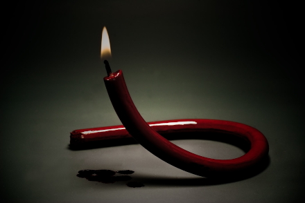 Bild einer Kerze, die wie eine
                            AIDS-Schleife geformt ist - Photo von Sergey
                            Mikheev (unsplash)